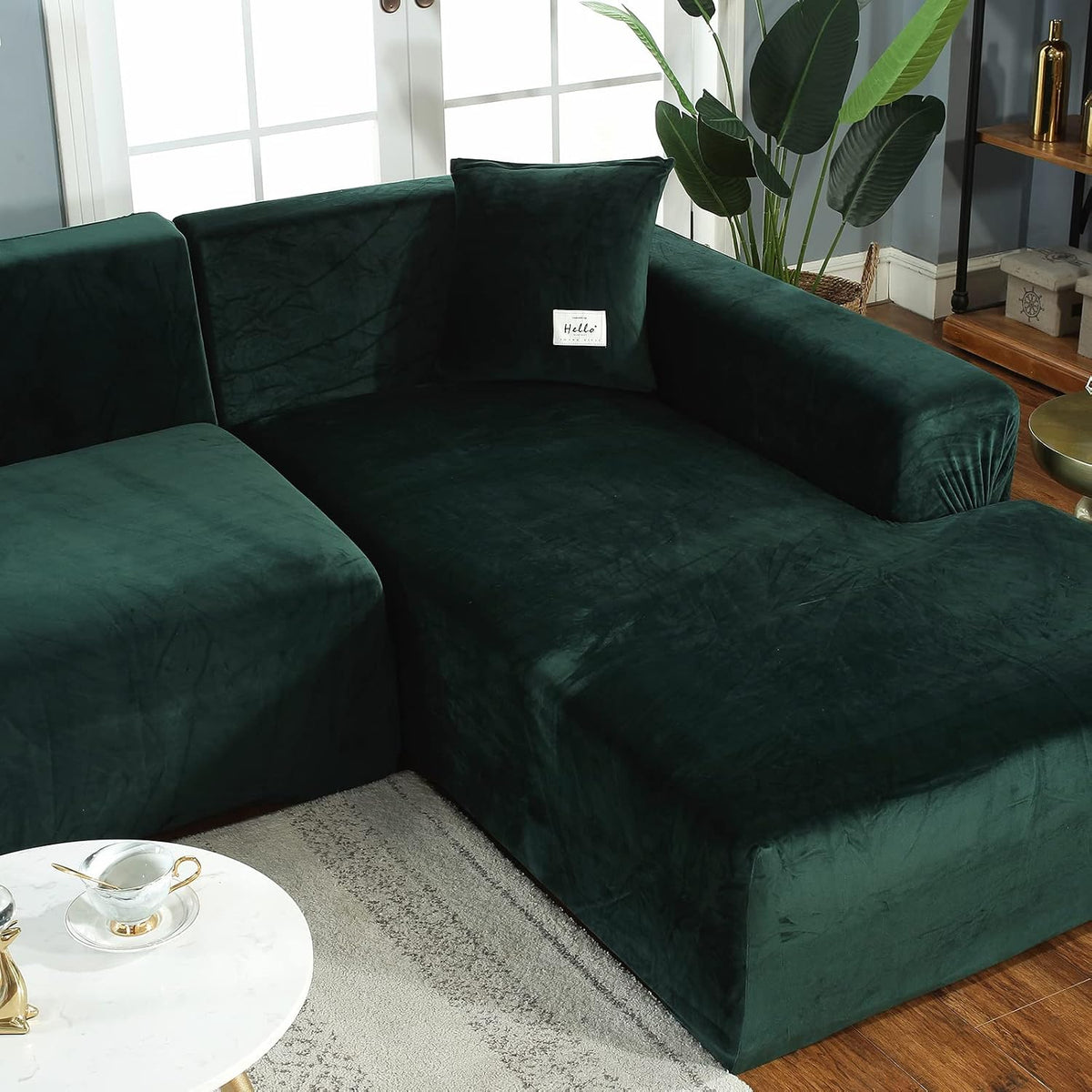 Close-up of chaise junction showing dark green velvet surface and a single pillow