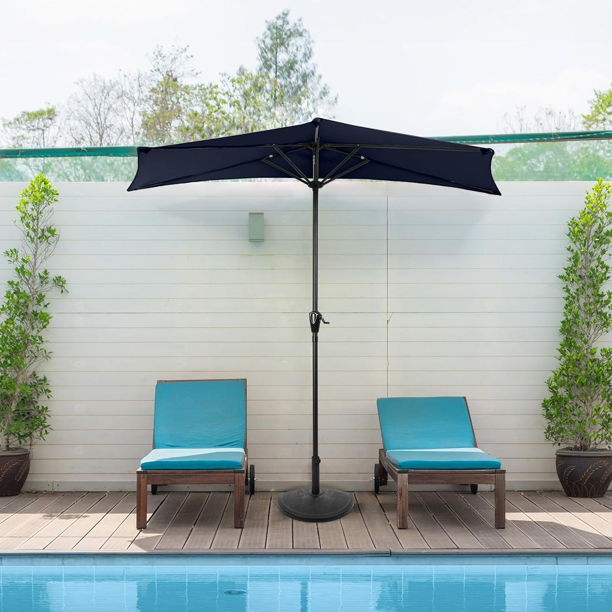 Navy blue half canopy umbrella set between two poolside lounge chairs on a deck