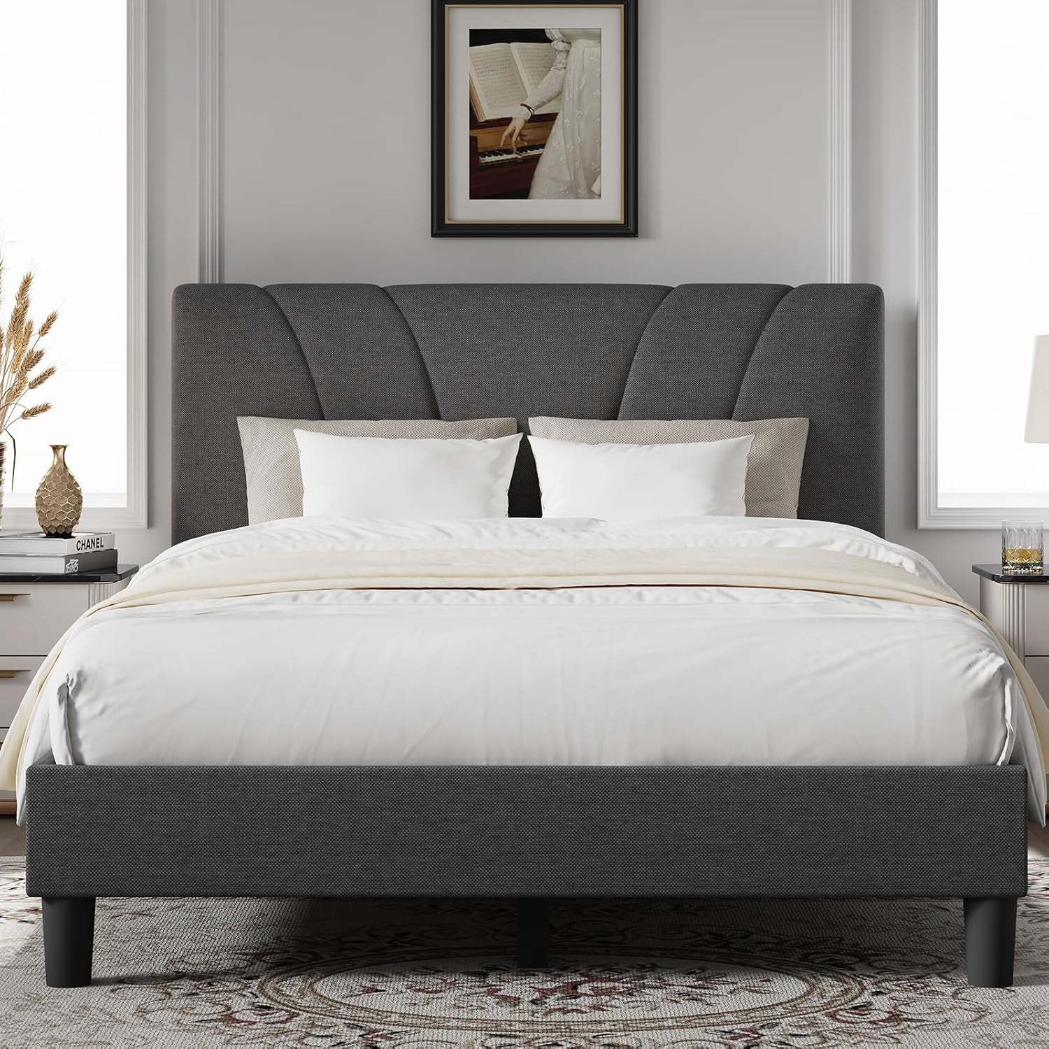 Front bedroom view of a dark gray upholstered bed with a fan-pattern headboard and white bedding.