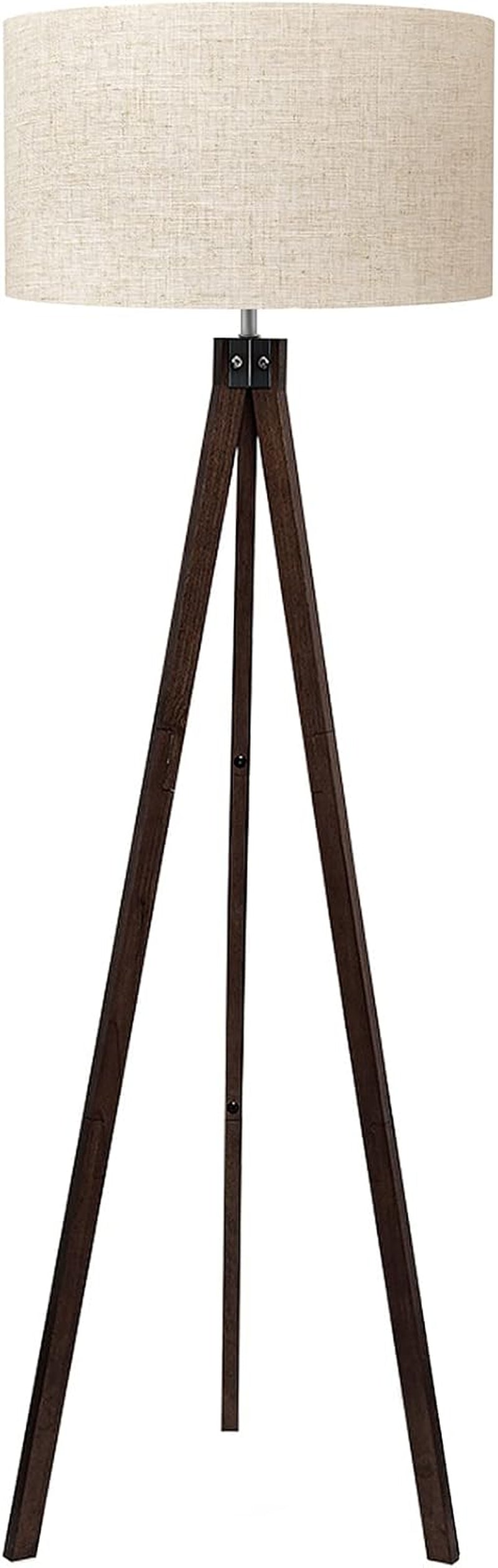 Full-length tripod floor lamp with dark brown wooden legs and a beige linen drum shade on a white background.