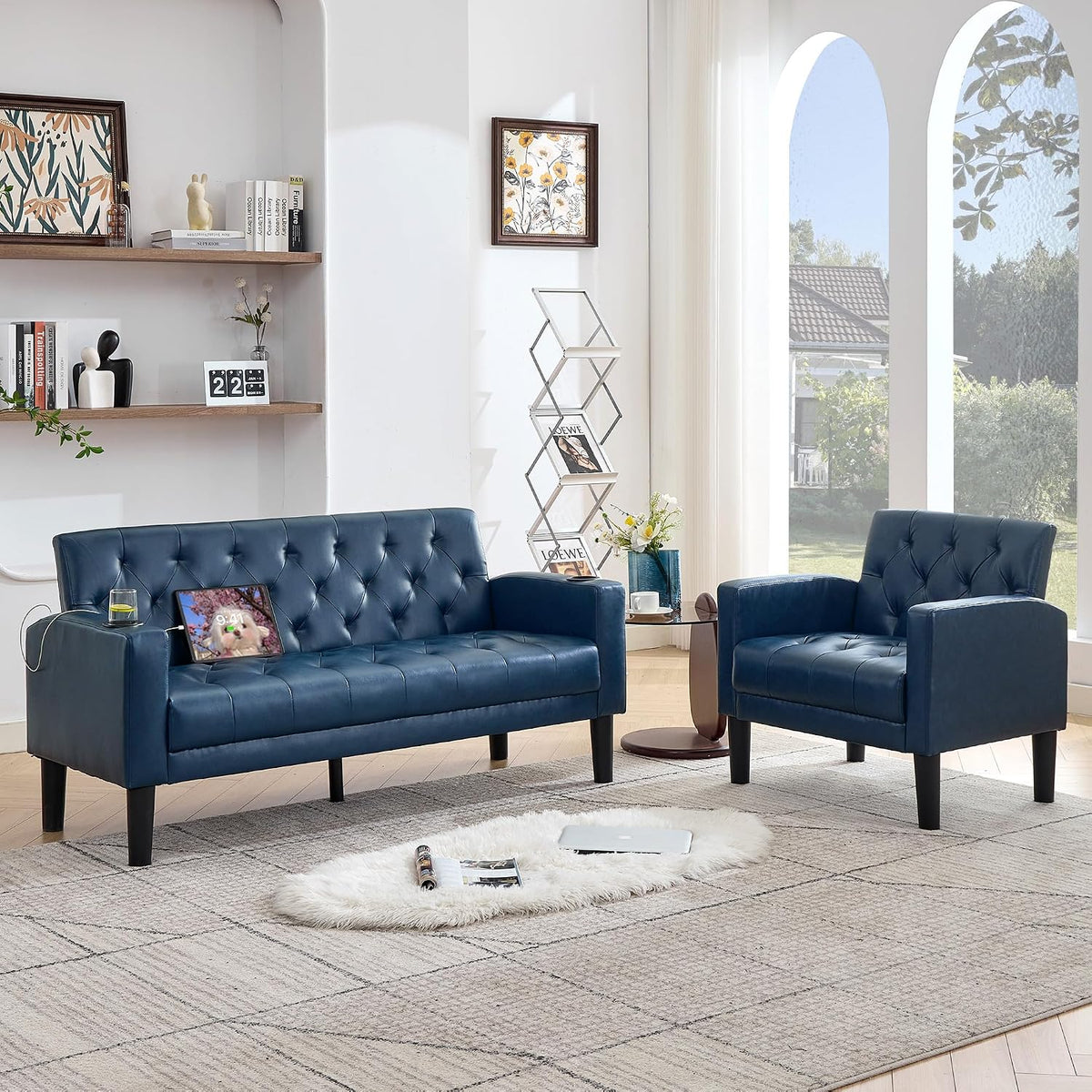 Blue tufted loveseat paired with a matching blue armchair in a sunlit room with arched windows.
