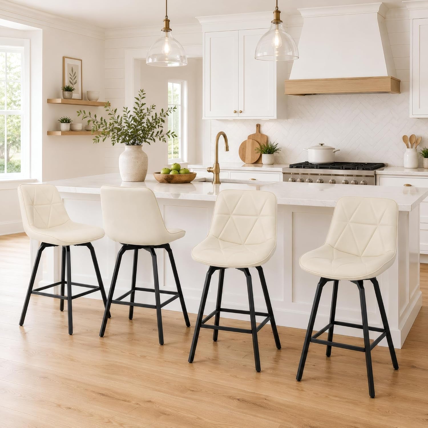 Four cream swivel counter stools lined up at a white kitchen island in a bright, modern kitchen