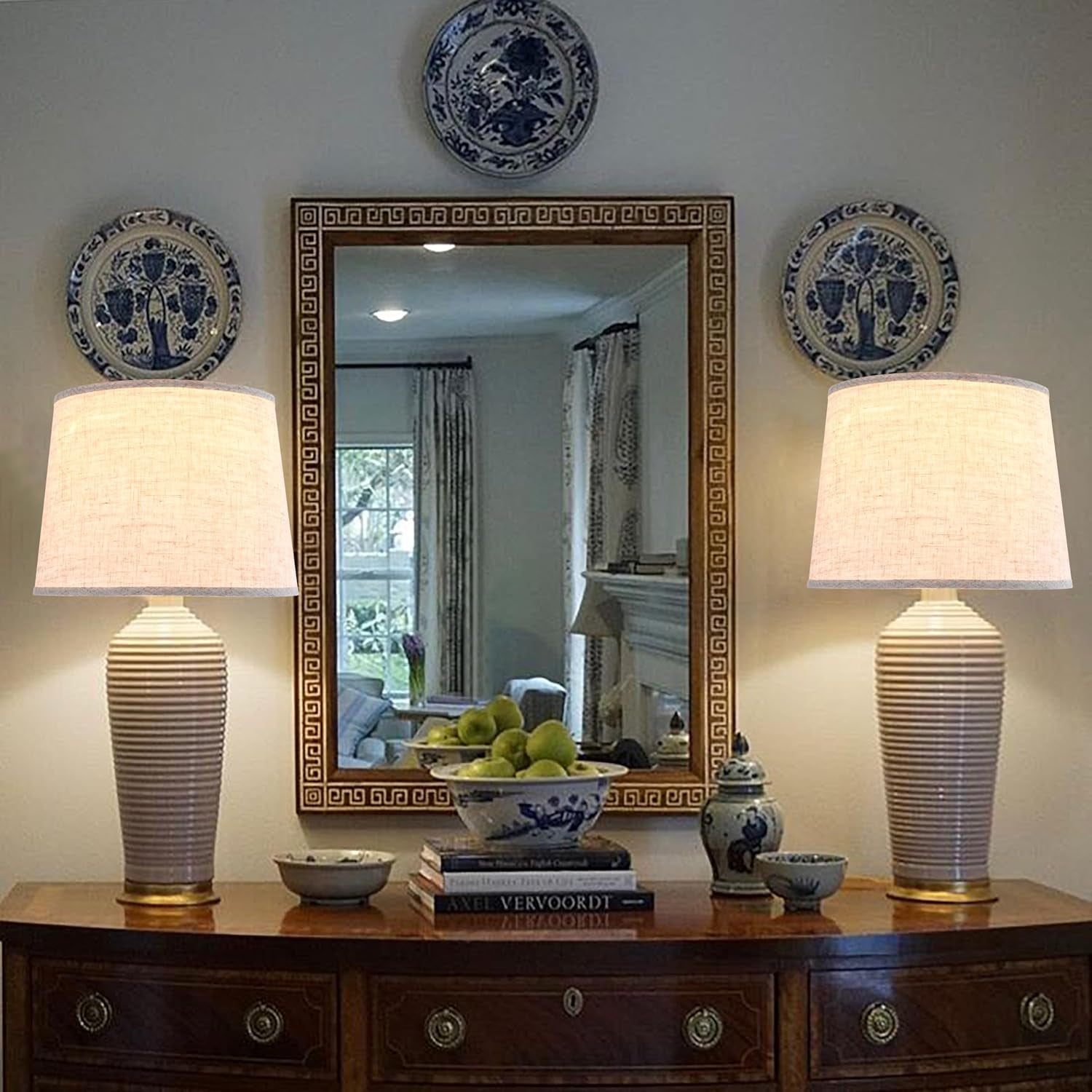 Pair of beige linen lampshades shown on table lamps in a traditional entryway vignette