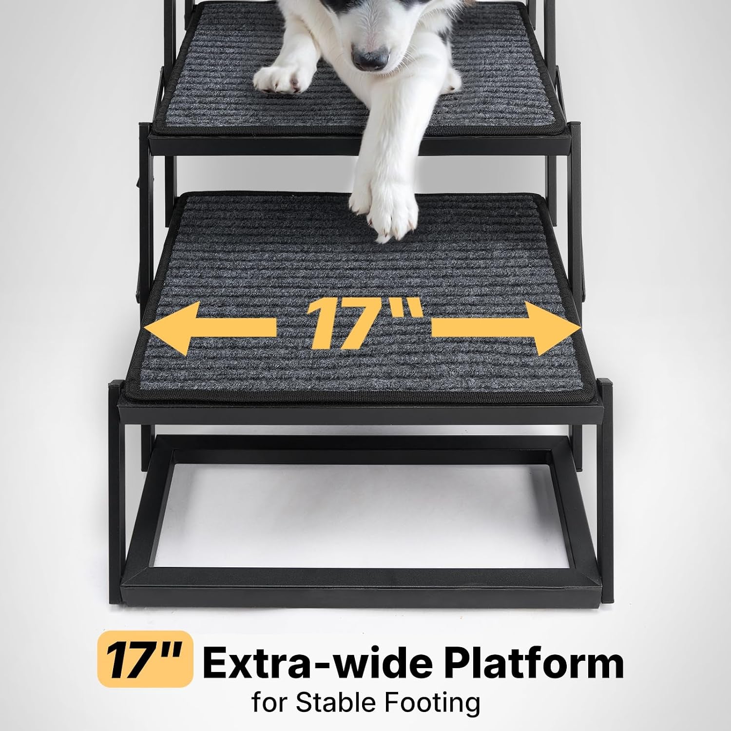 Close-up of 17-inch extra-wide black step platform with grey non-slip rug and dog paws on the top step