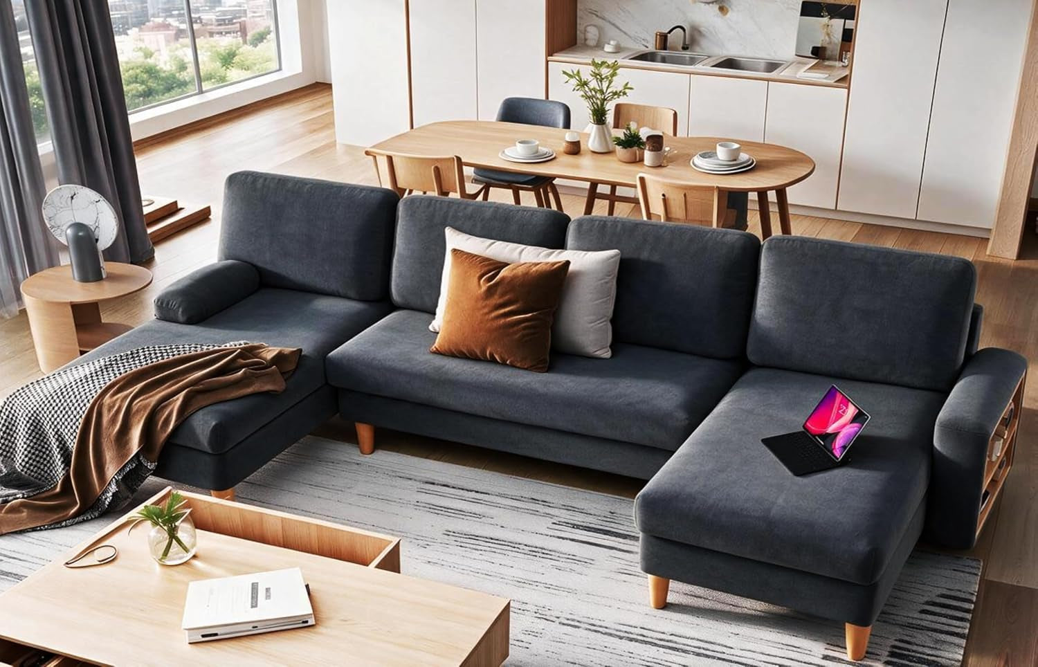 Large dark blue L-shaped sectional with chaise, wooden legs and pillows in an open kitchen living space