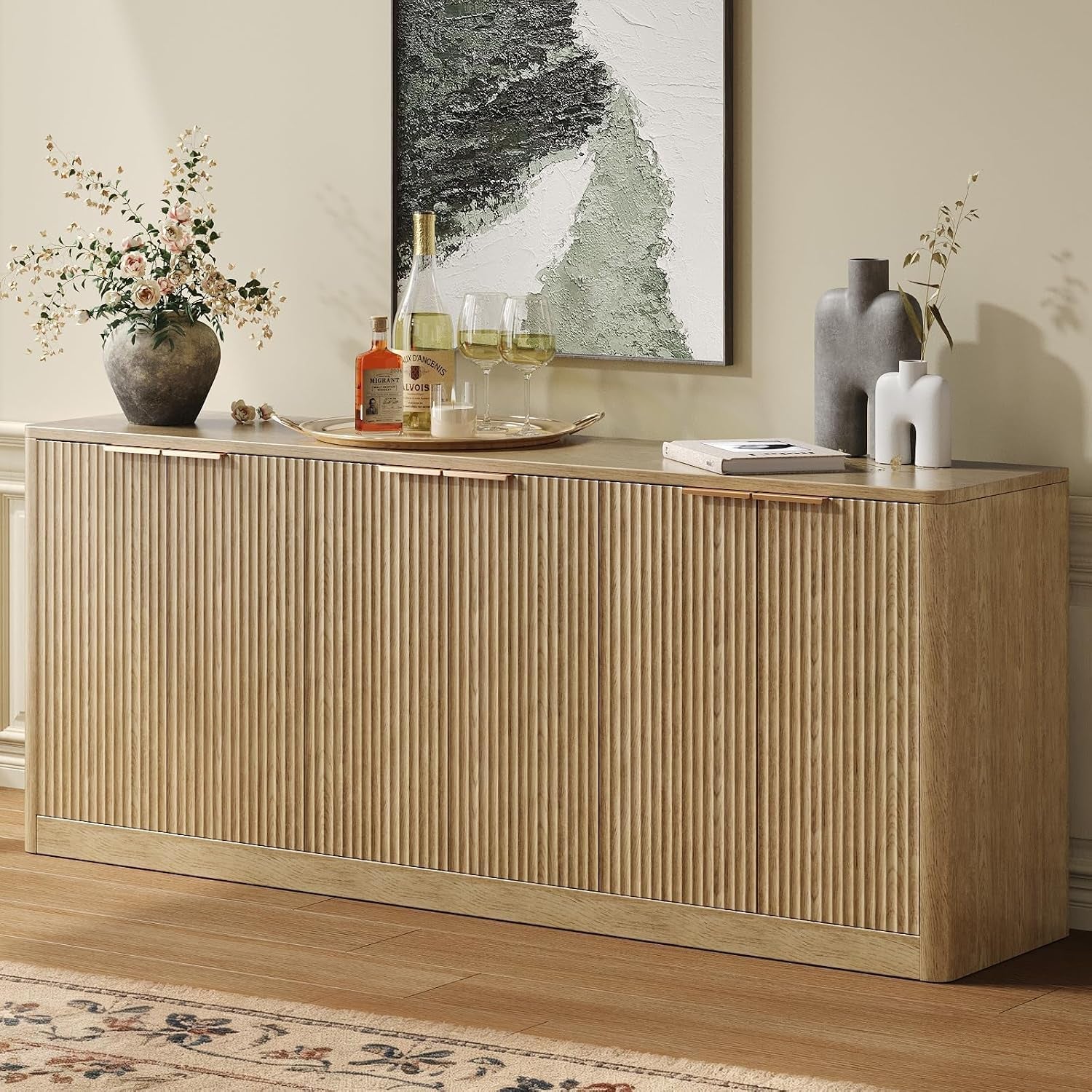Light walnut fluted six-door buffet against a cream wall with vases and artwork on top.
