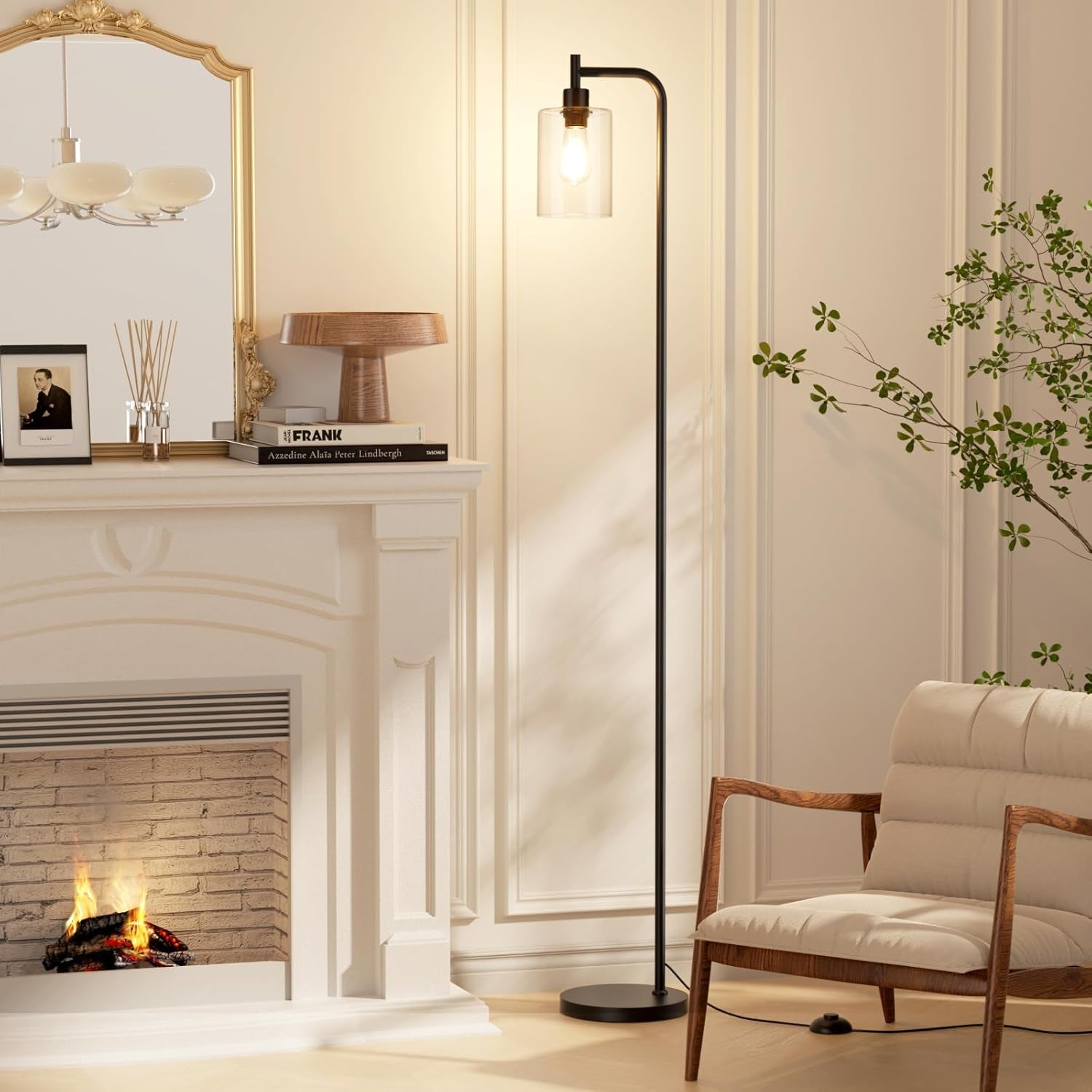 Tall black standing lamp with clear glass shade placed next to a fireplace mantel