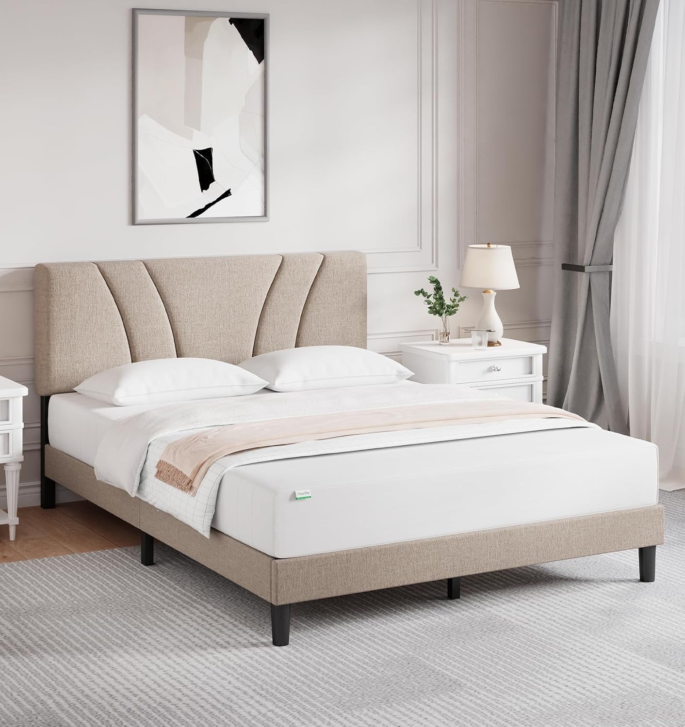 Angled bedroom view of a beige upholstered platform bed with a fan-pattern headboard.
