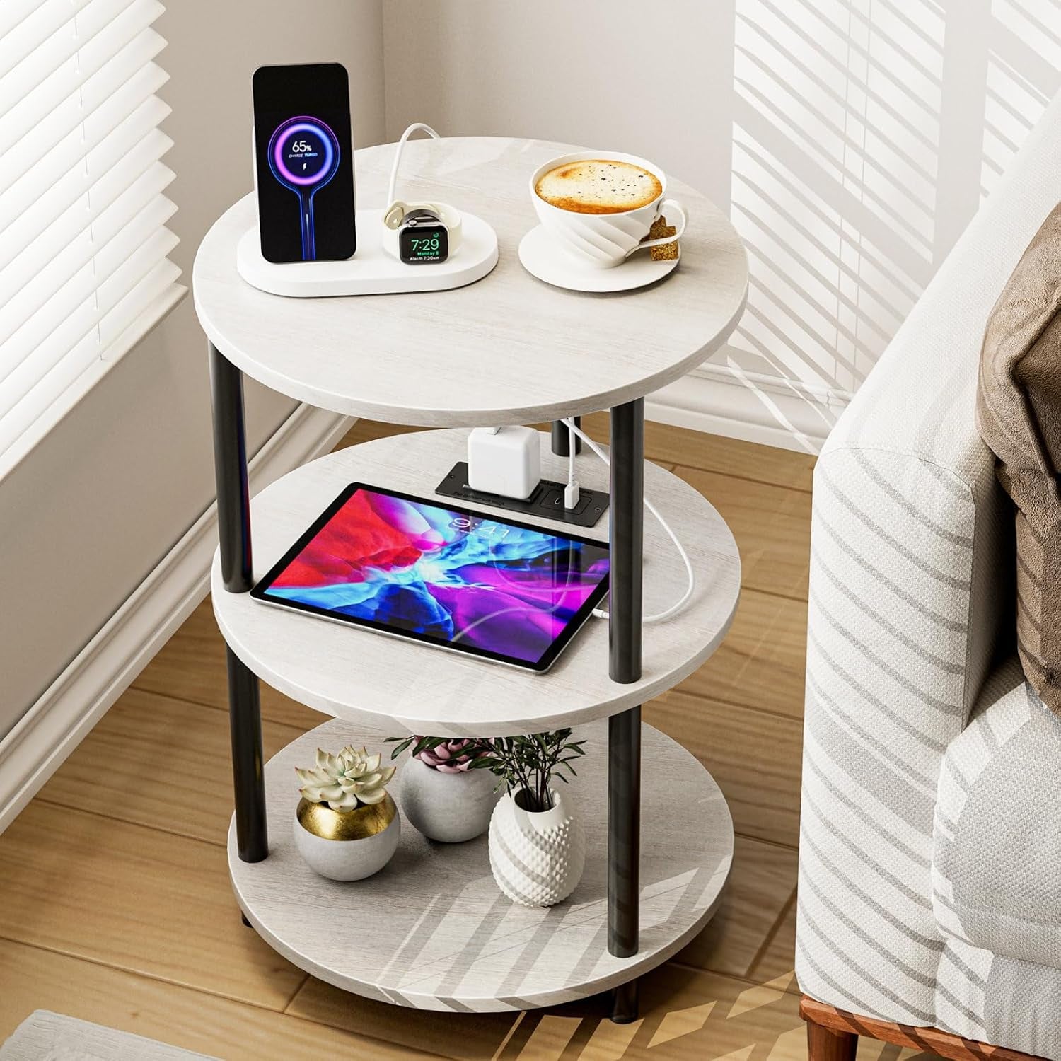 Light gray three-tier round table with a wireless charger on top and a tablet on the middle shelf.