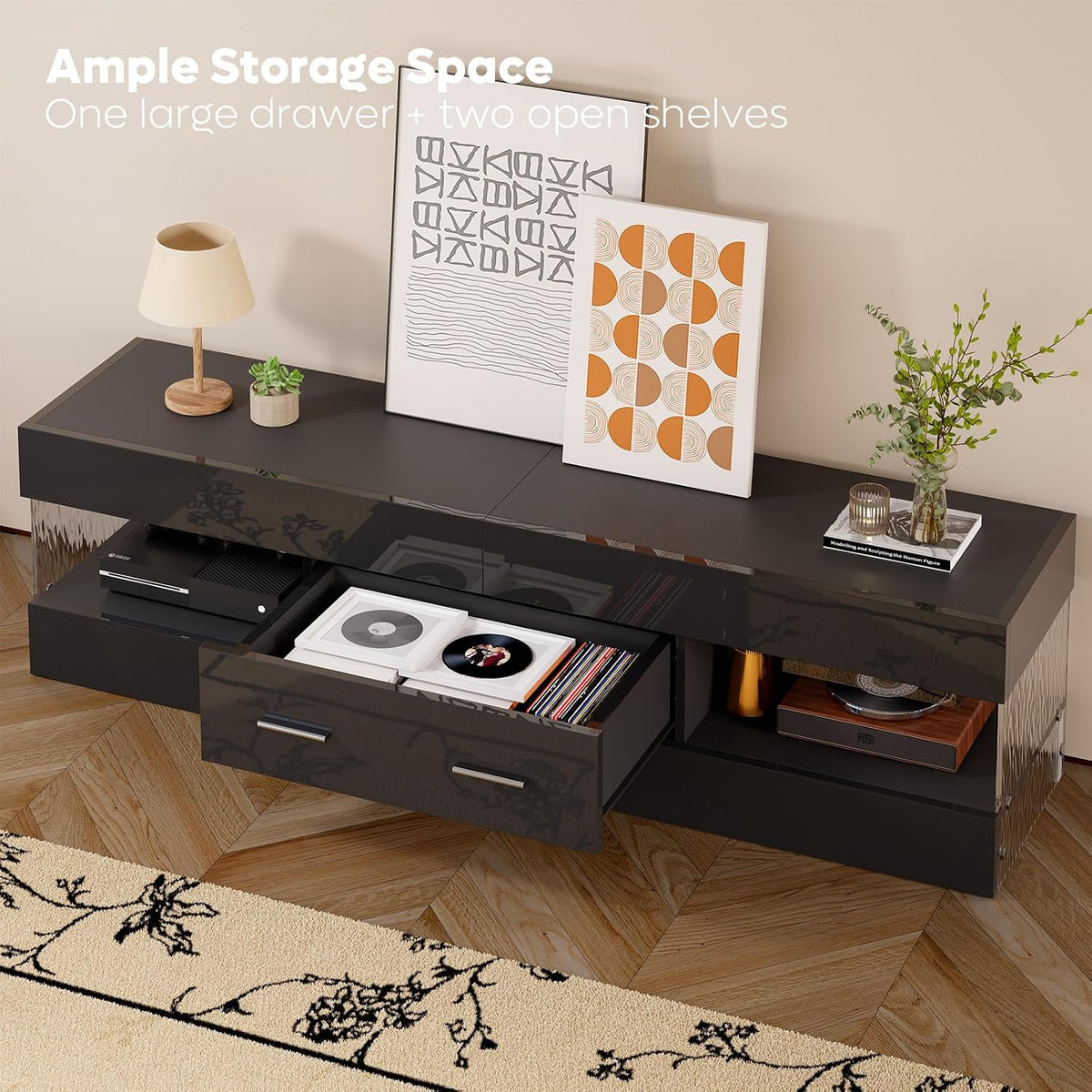 Glossy black TV stand with center drawer open showing storage space and two open side compartments