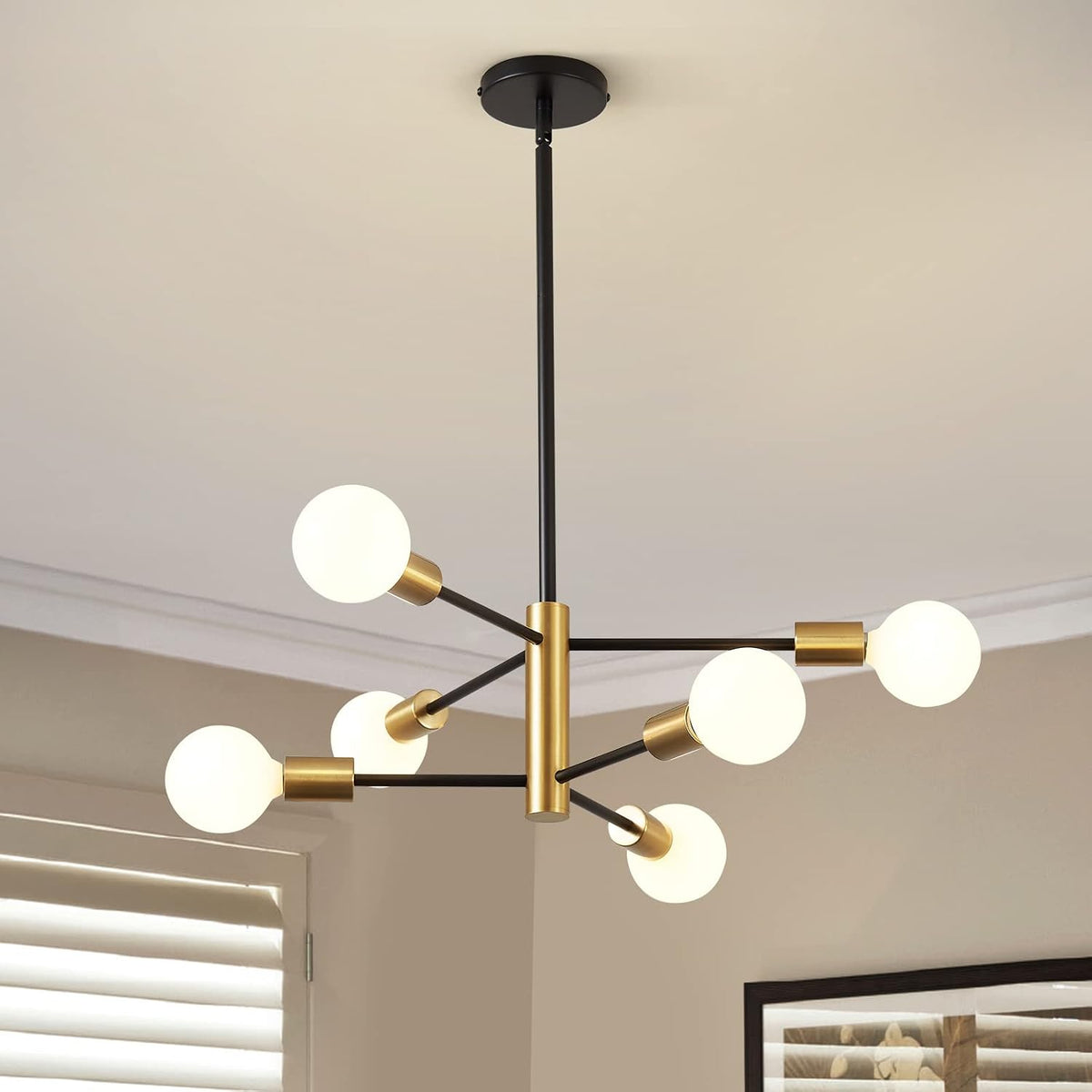Black-and-gold chandelier with six illuminated white globe bulbs hanging from a short rod.