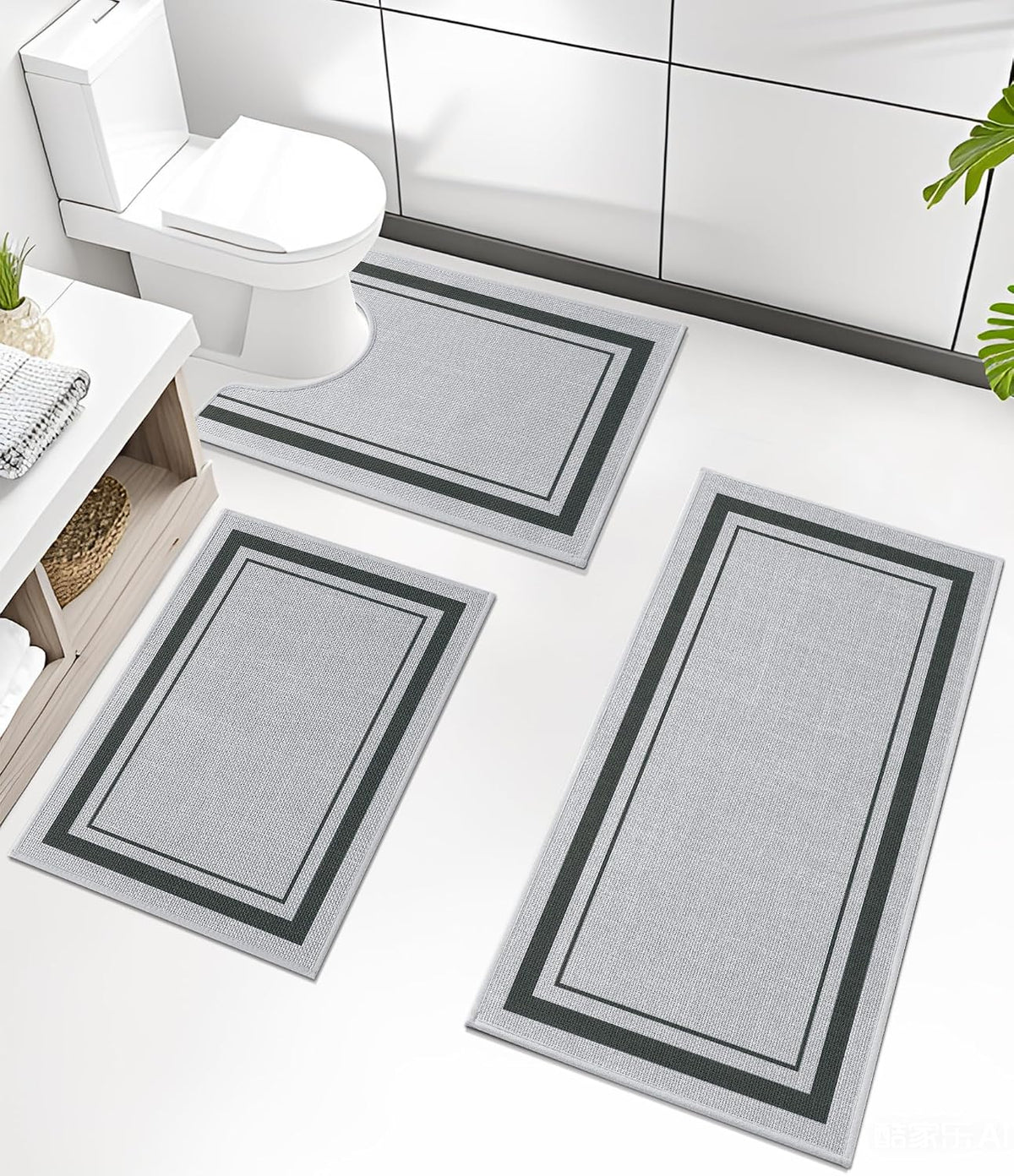 Three matching rectangular mats arranged on a bright white bathroom floor near a toilet and shelving
