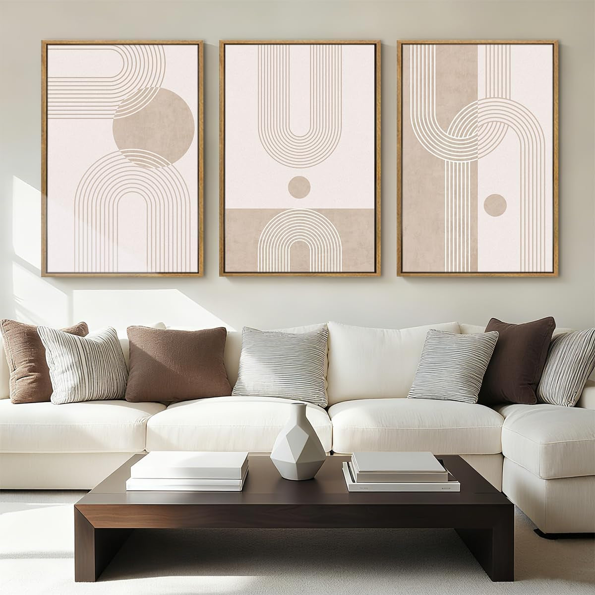Neutral living room with three beige abstract geometric prints in wood frames above a sectional sofa.