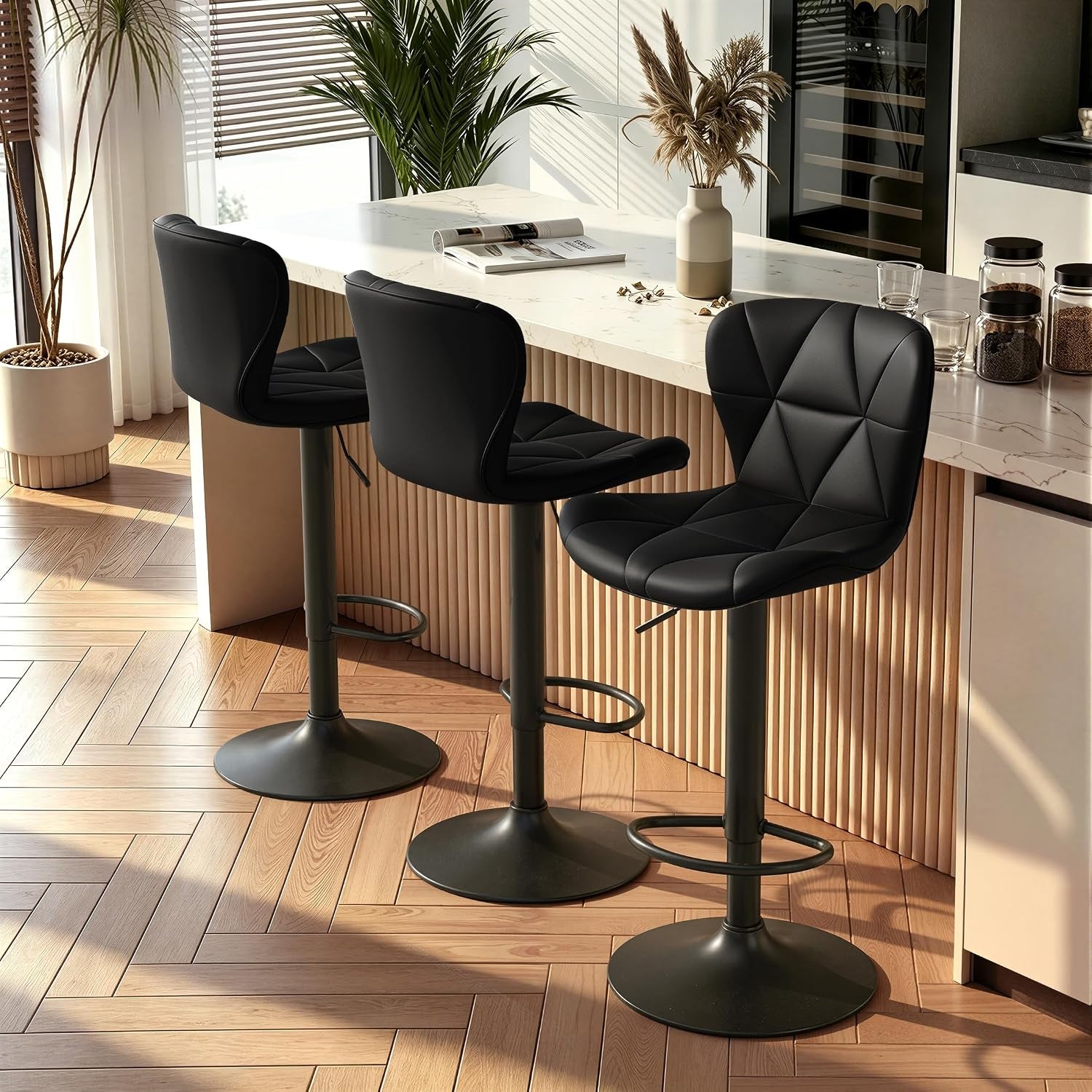 Three black bar stools staged along a fluted wood-front counter with jars and glassware on the surface.