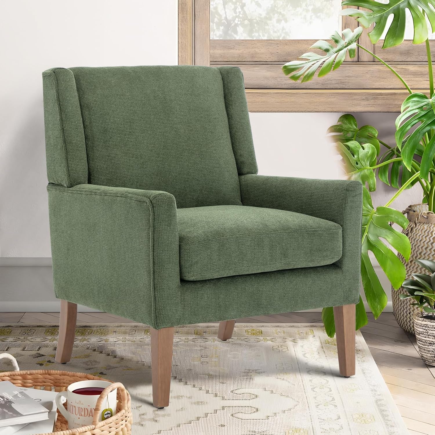 Green chenille wingback accent chair angled front view with natural wood legs in a living room setting