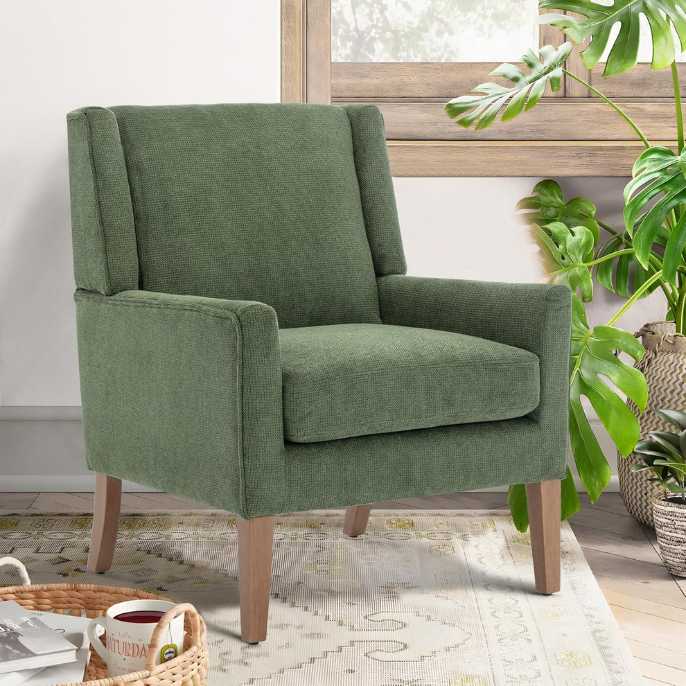 Green chenille wingback accent chair angled front view with natural wood legs in a living room setting