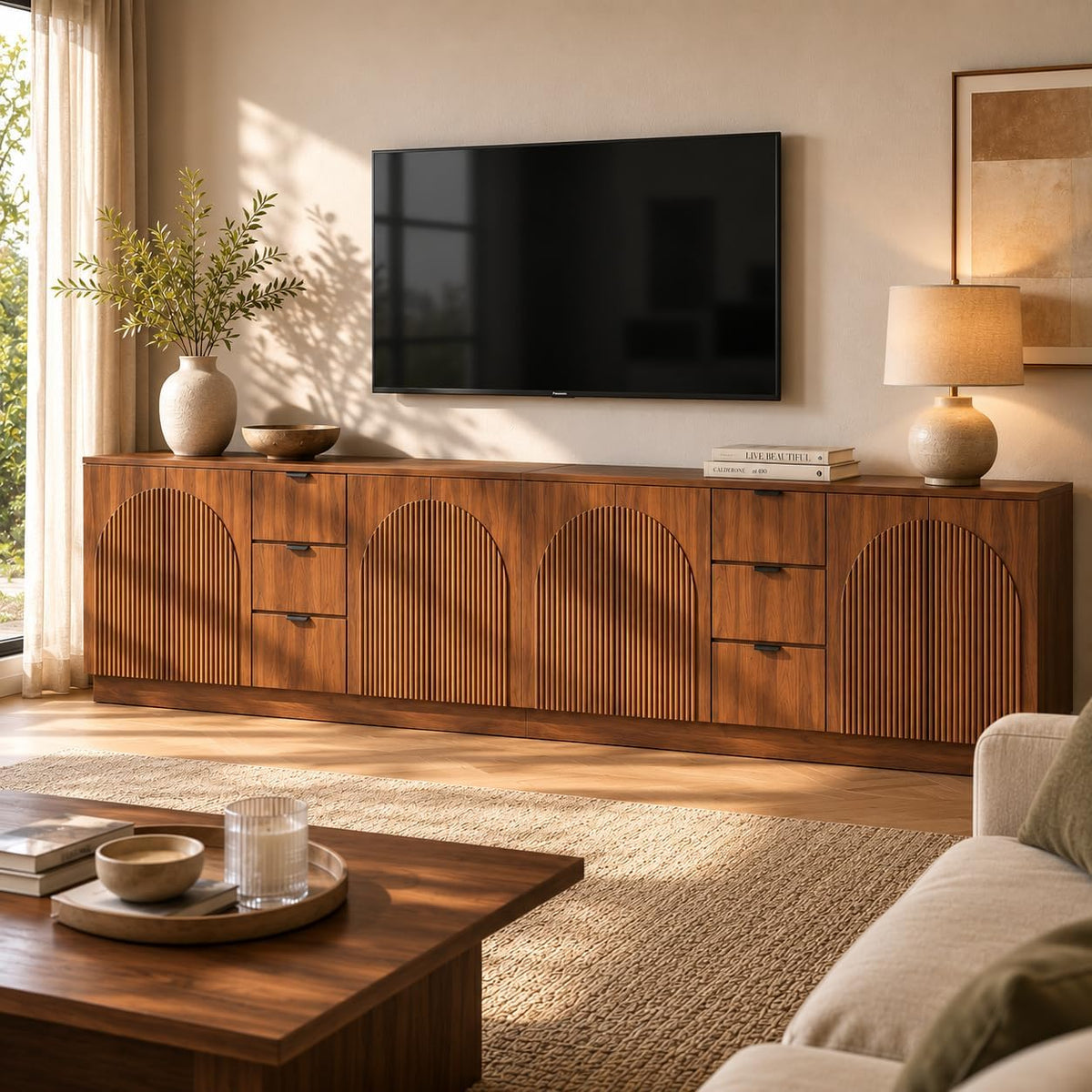 Long walnut sideboard with four arched reeded doors and two vertical sets of drawers in a sunlit living room.