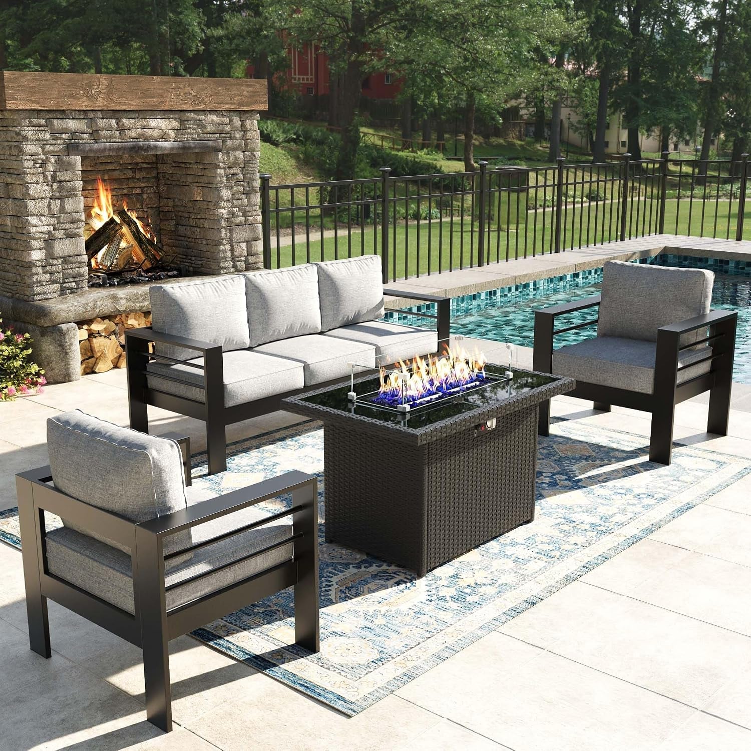 Outdoor patio conversation set with dark metal frames, gray cushions and a rectangular fire table beside a pool