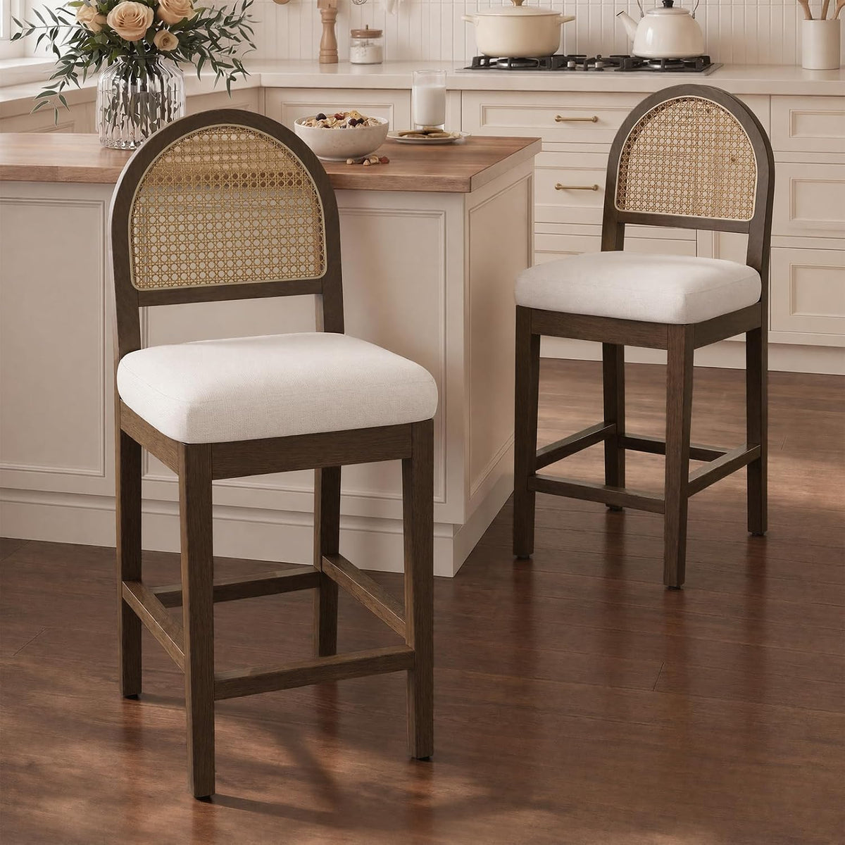Two dark-wood rattan-back counter stools with cream chenille seats beside a kitchen island
