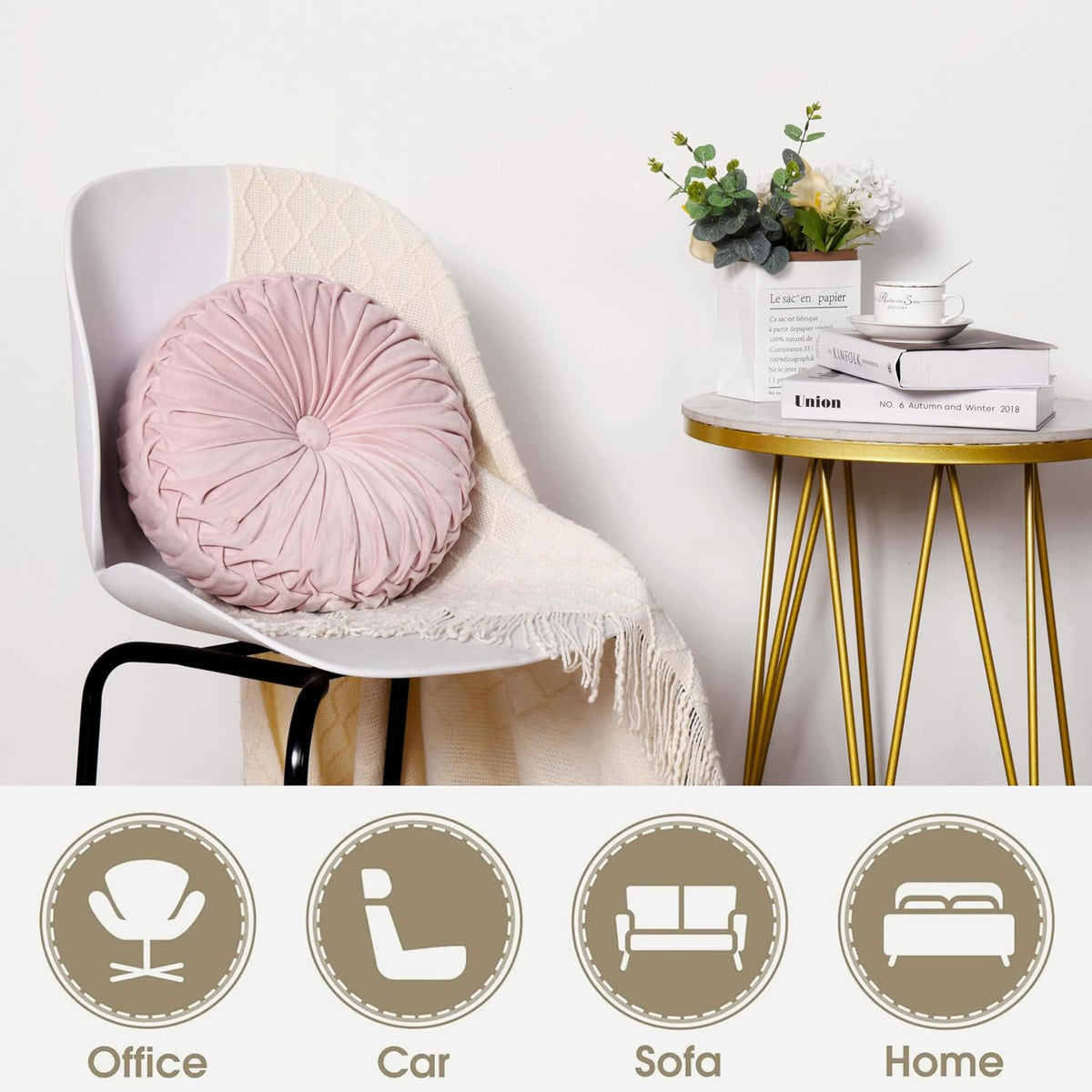Pink velvet ruched round pillow styled on a white chair with a cream throw and a gold-legged side table