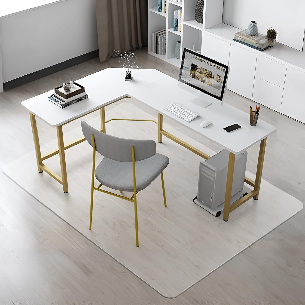 Angled room view showing a clear rectangular mat under an L-shaped white desk and a gray chair on a pale wood floor.