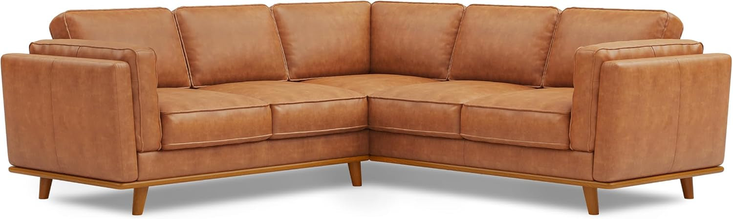 Cognac-colored L-shaped corner leather sofa with wooden base and tapered legs.