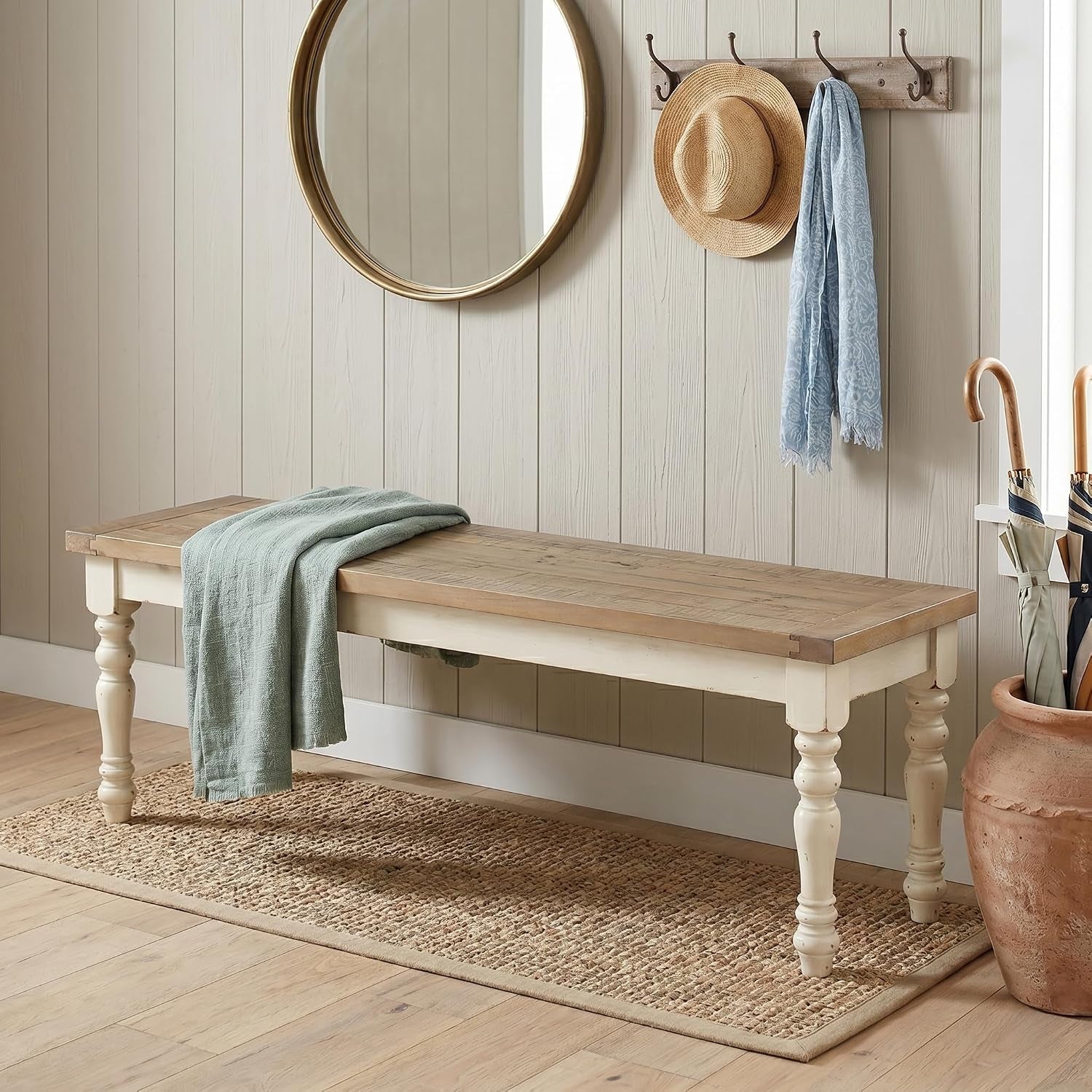 Long matching bench with distressed oak top and turned antique white legs styled in an entryway with a round mirror