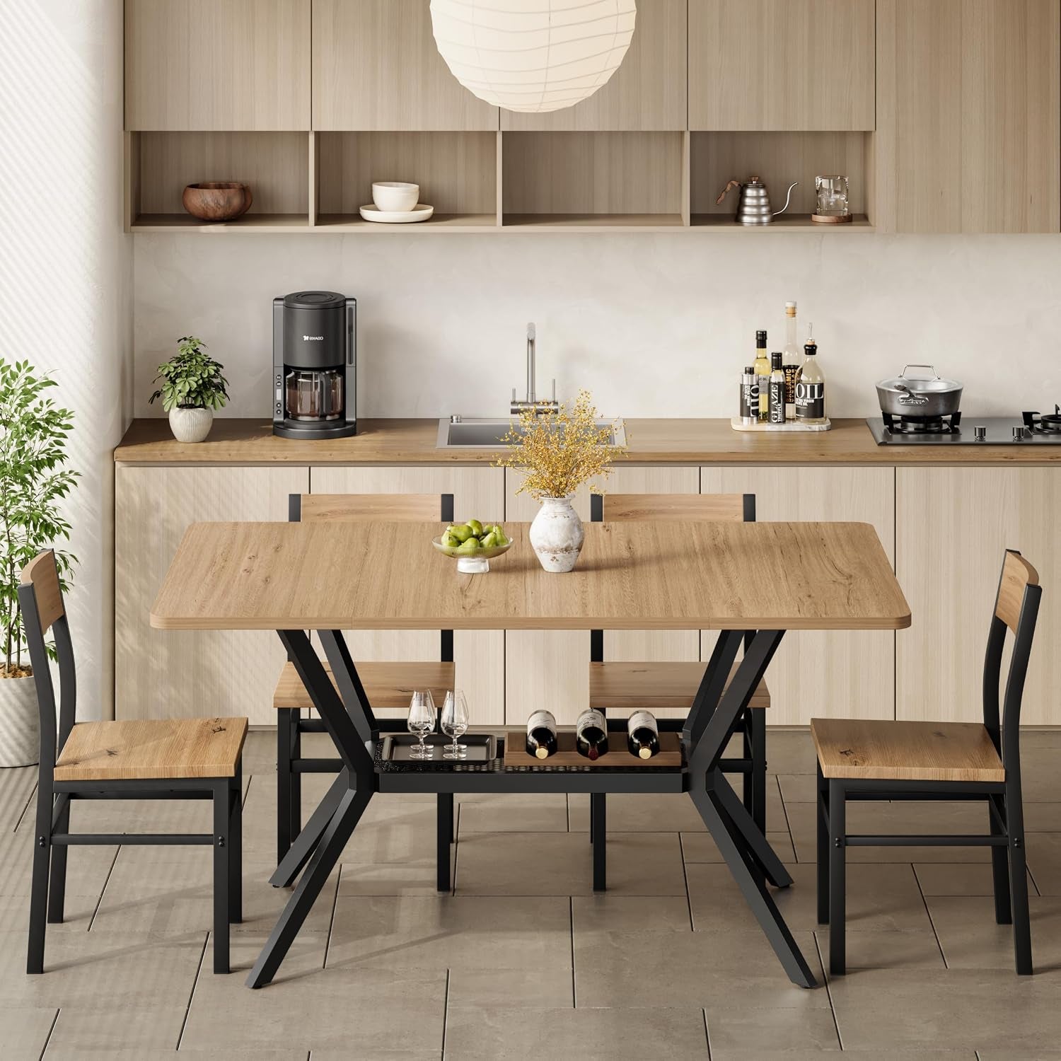 Front view of dining table set in a kitchen with walnut top, black metal X-base and four chairs tucked under