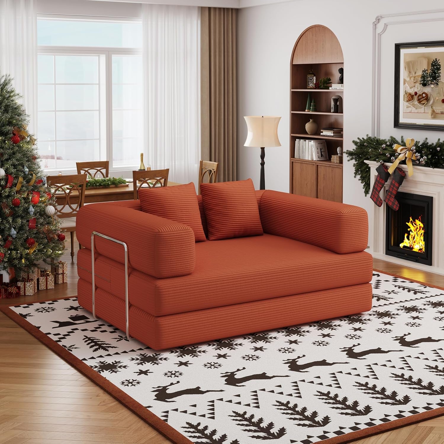 Low-profile rust-orange corduroy two-seat convertible floor sofa shown in a festive living room scene