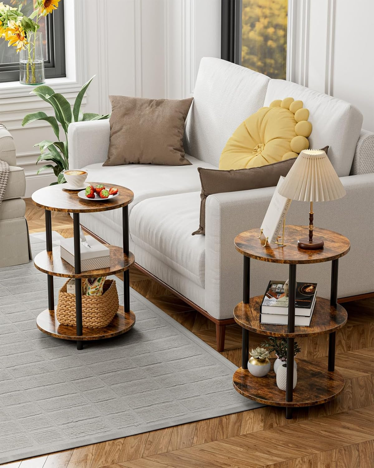 Two matching round three-tier tables in a living room setting beside a white sofa on a rug