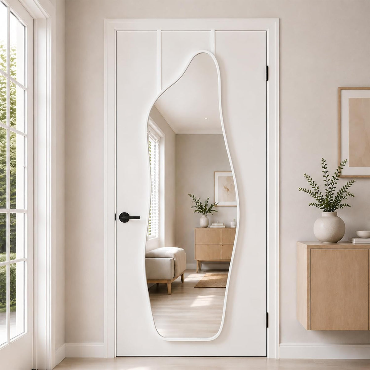 Full-length mirror with an organic curved opening mounted on a white door, white frame visible.