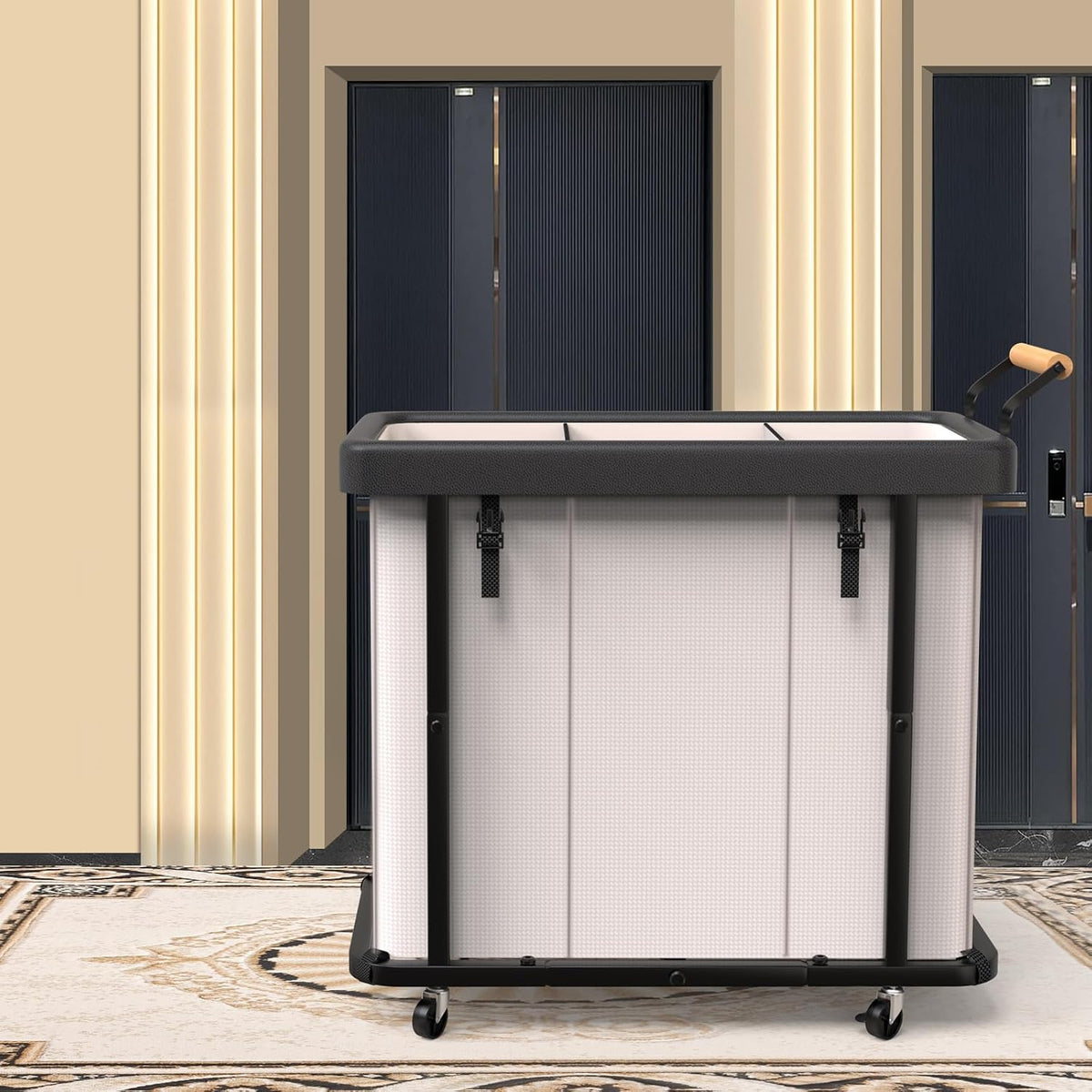 Front view of the three-compartment hamper in a hallway setting, lid closed and casters visible