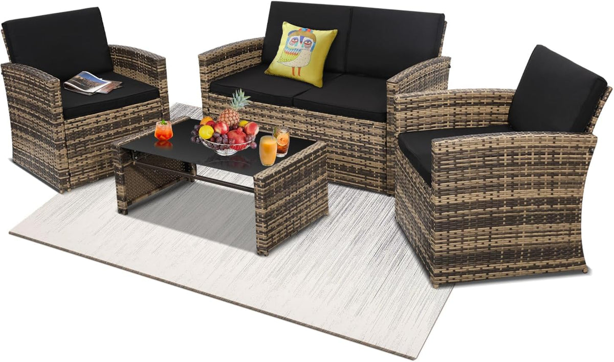 Two armchairs and a loveseat with black cushions flanking a glass-top coffee table on a light rug.