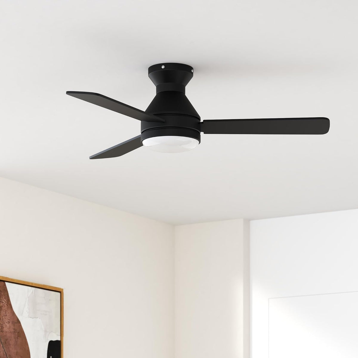 Black low-profile ceiling fan flush-mounted to a white ceiling, angled view in a neutral living room