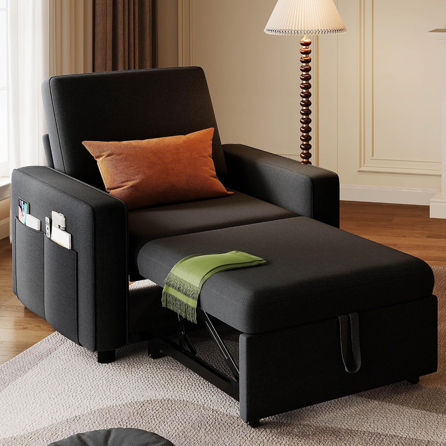 Front-angle view of the black chaise mode with armrest storage pockets and decorative pillow
