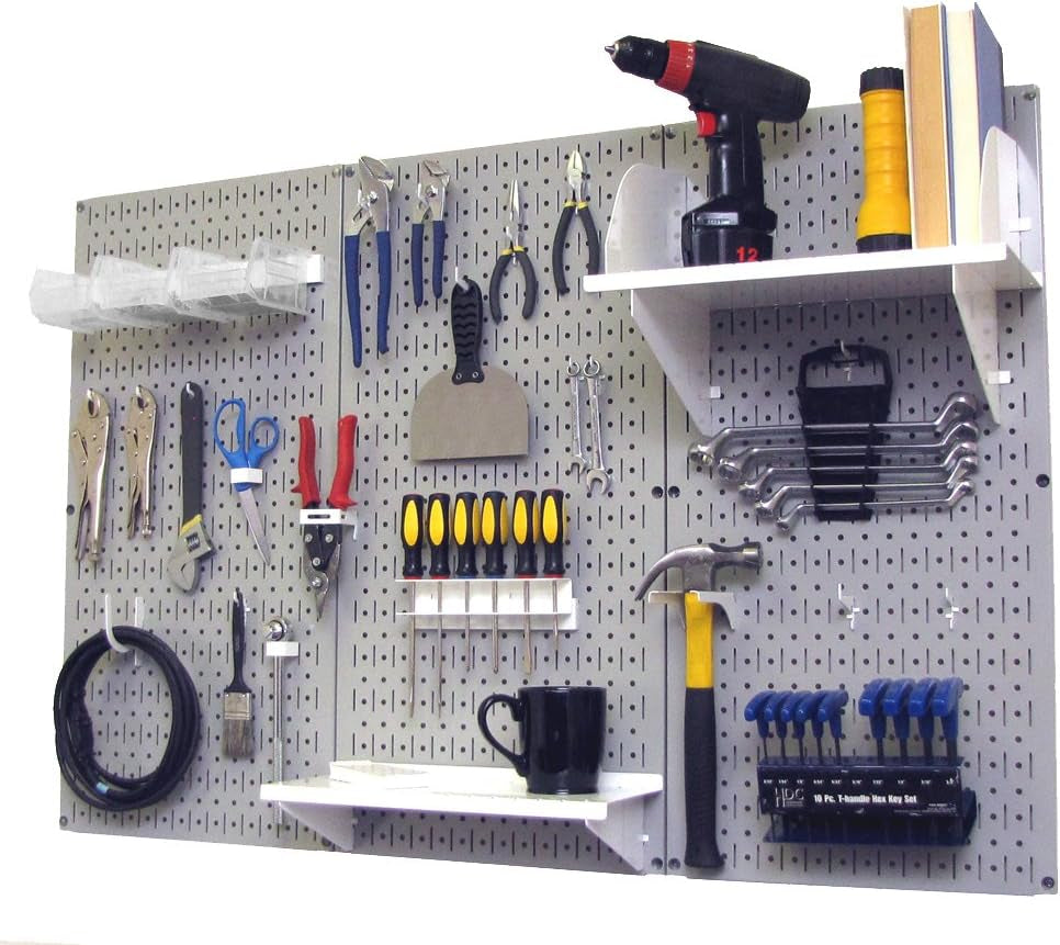 Mounted light-gray metal pegboard with shelves and assorted hand tools and a black mug.