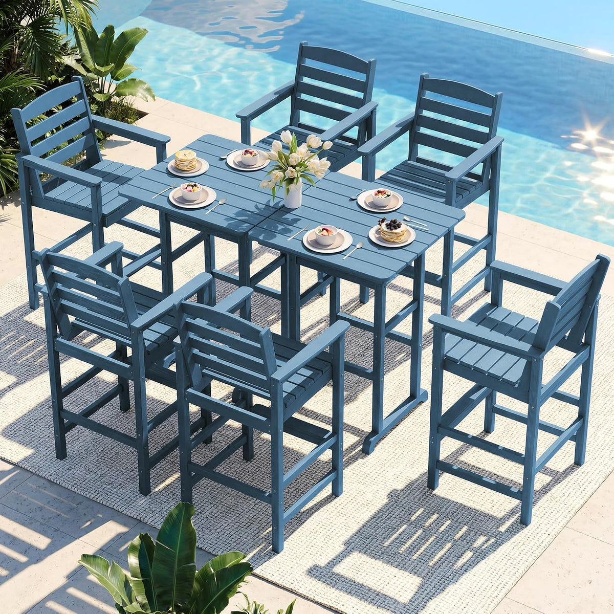 Outdoor bar-height dining set with six high-arm chairs and a rectangular table by a pool, blue finish.
