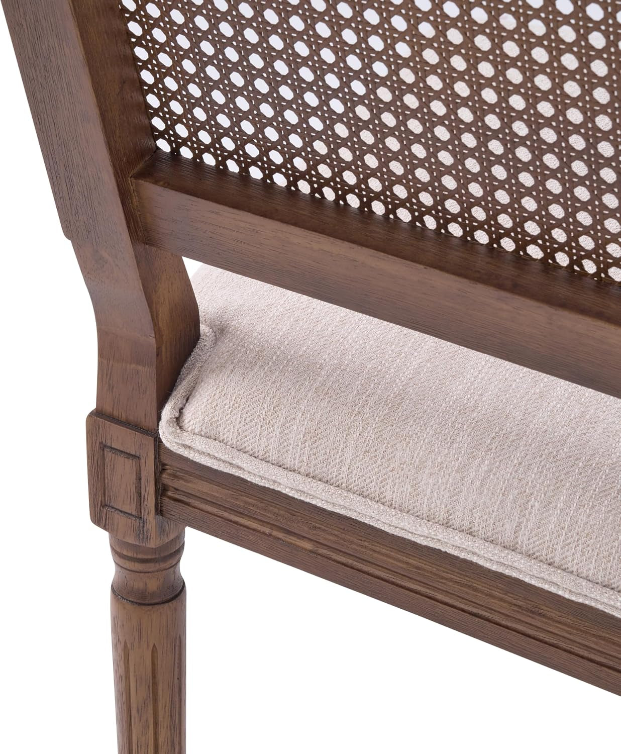 Close-up of the chair's seat corner showing beige fabric cushion, walnut wood frame and woven cane back edge.