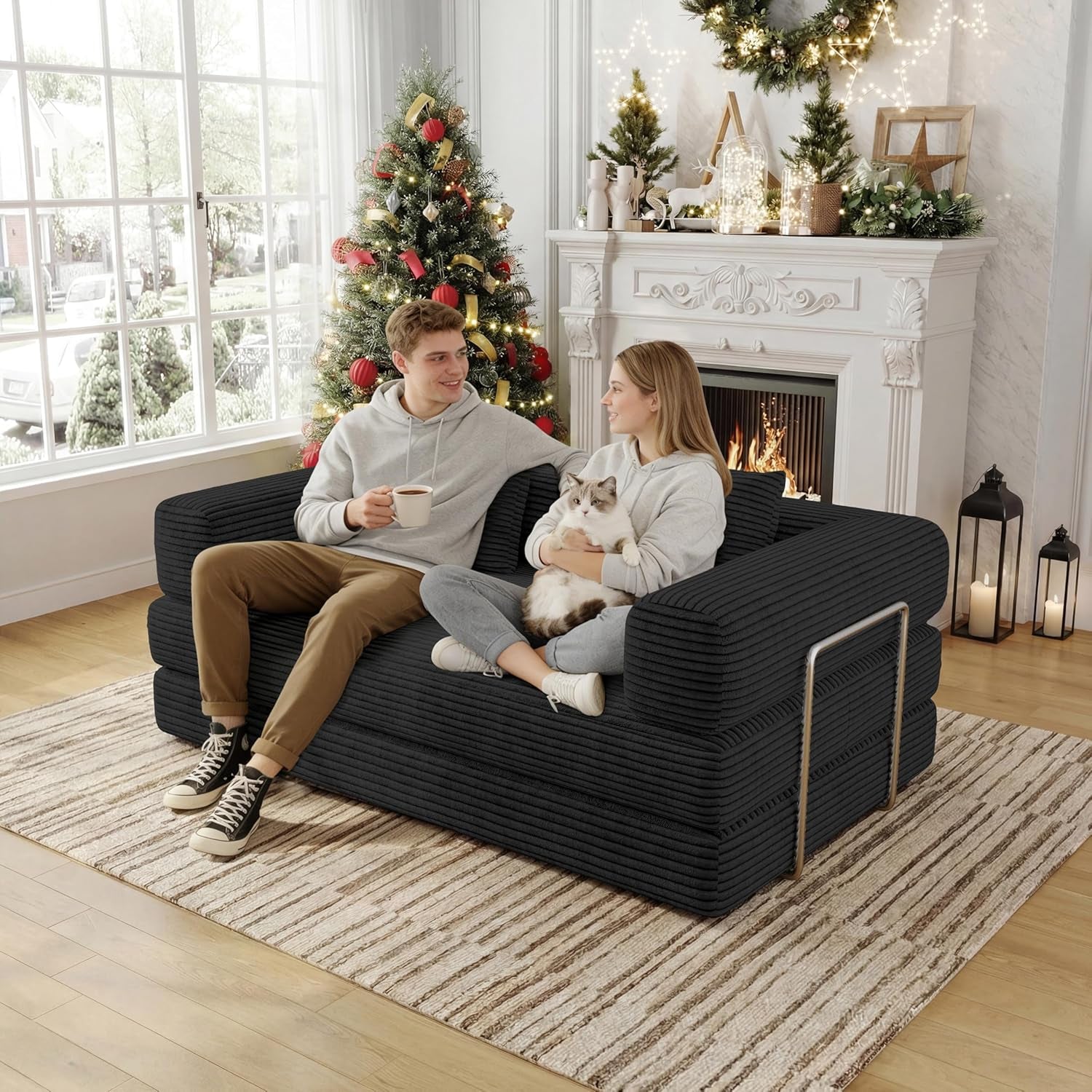 Couple sitting on the black corduroy 2-seat convertible floor sofa in a decorated living room