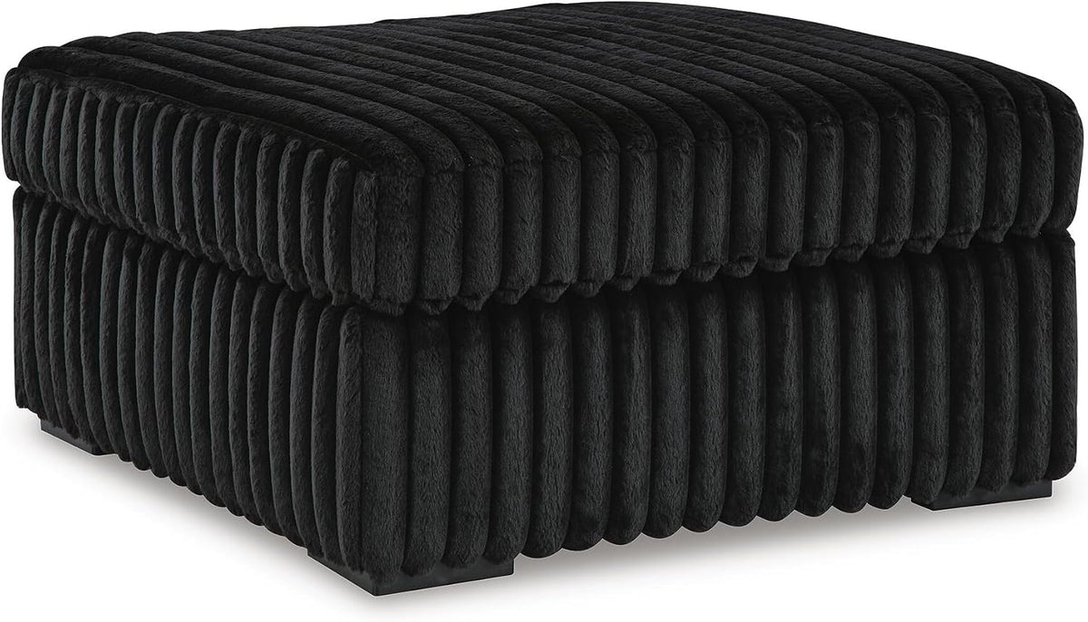 Three-quarter view of a square ottoman with plush vertical ribbed fabric and low block feet.