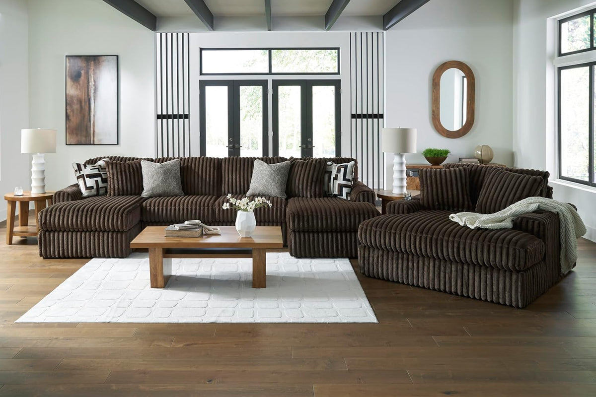 Wide living room view showing a chocolate-brown ribbed sectional with oversized chaise, coffee table, and decor.