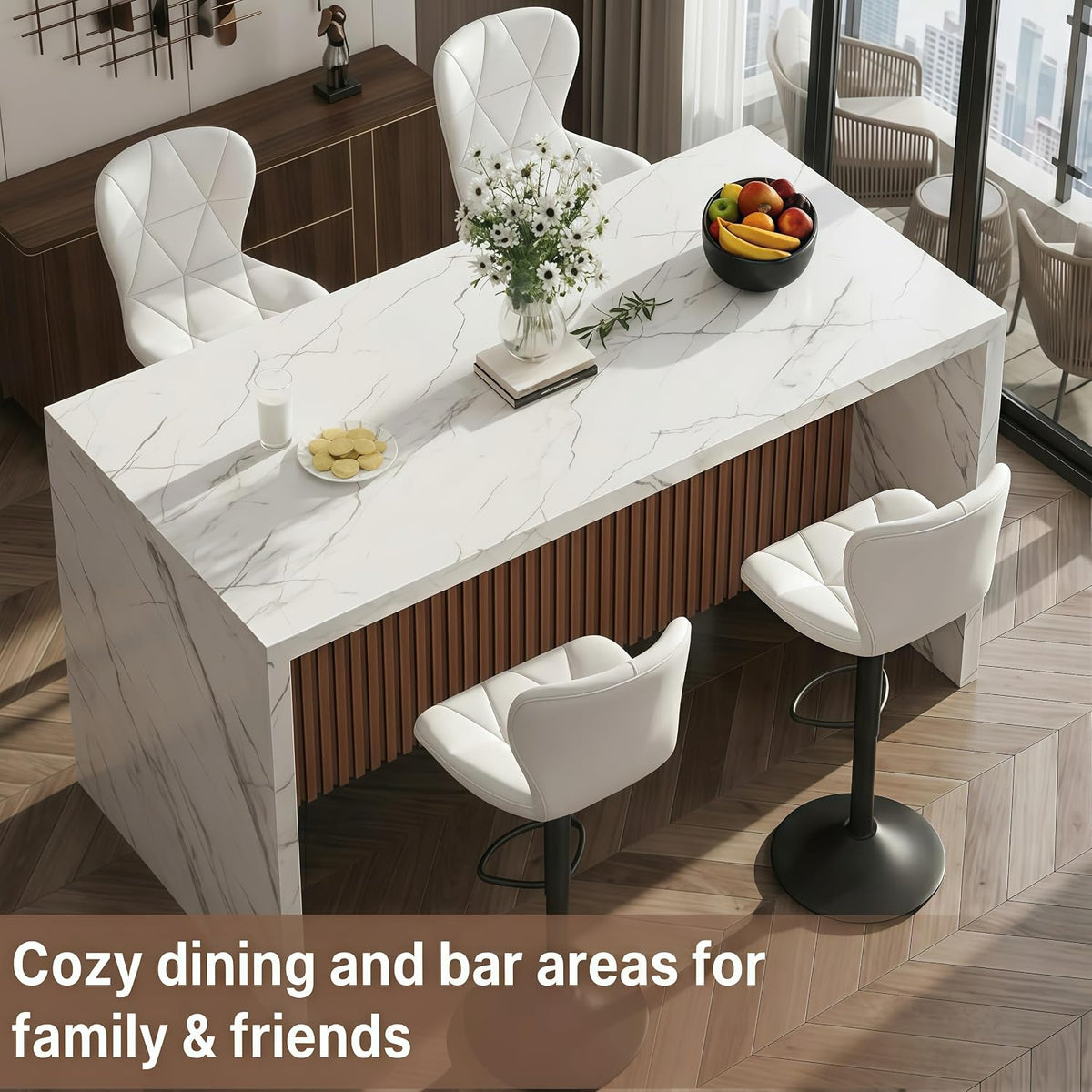 Elevated angle highlighting marble-wrapped island end, vertical wood slats on the base and two white quilted counter stools.