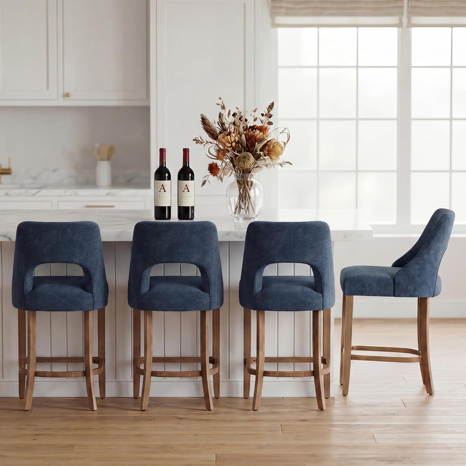 Three deep-blue upholstered counter stools facing the camera with a fourth stool shown in side profile at the far right.