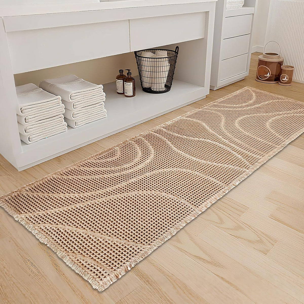 Angled close view of a beige waffle runner mat placed beside open shelving filled with folded towels