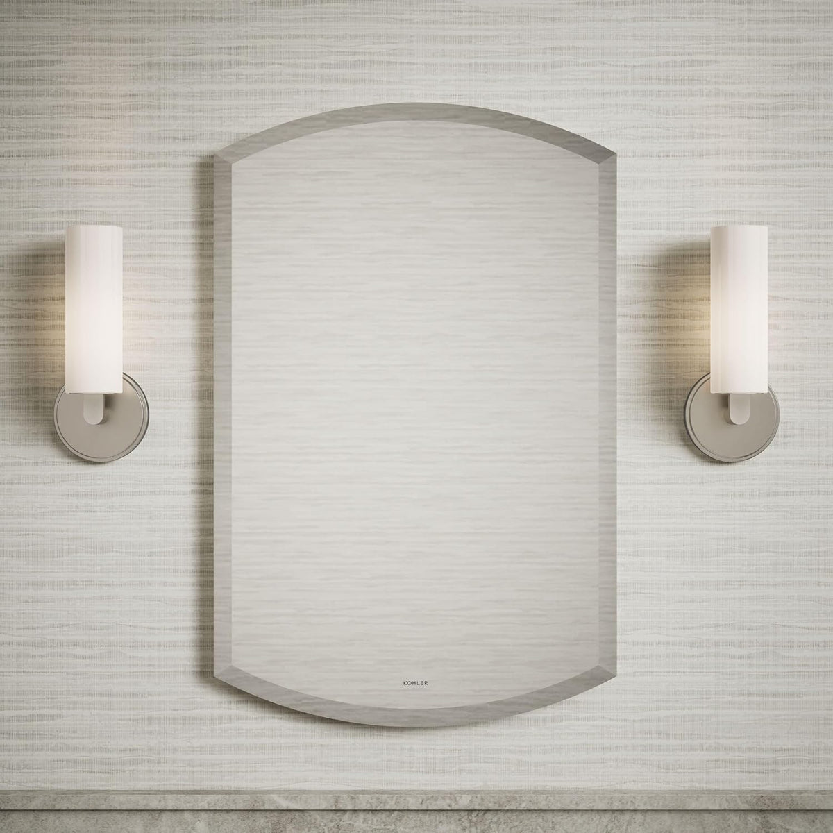 Arched beveled mirror cabinet mounted on wall between two cylindrical wall sconces in bathroom setting