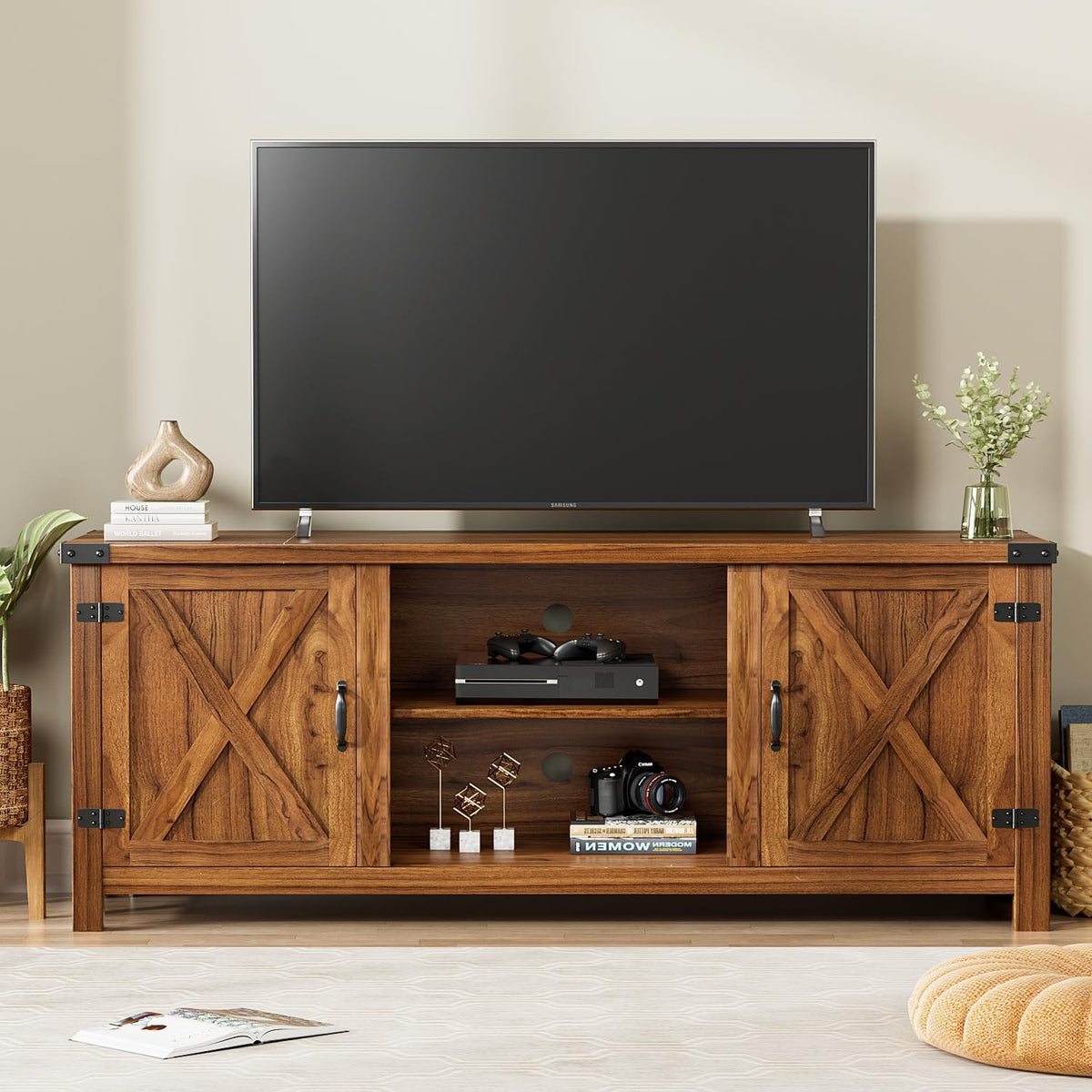 Frontal TV console in warm brown finish with center open shelving holding electronics and decorative items.