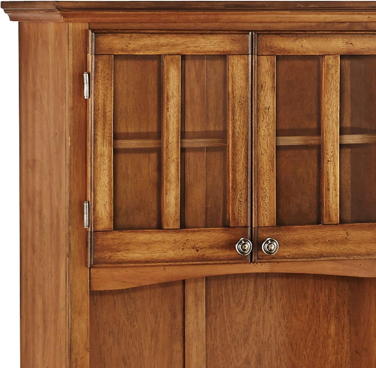 Close-up of brown wooden hutch upper cabinet showing two glazed paneled doors, round metal knobs, and wood grain.