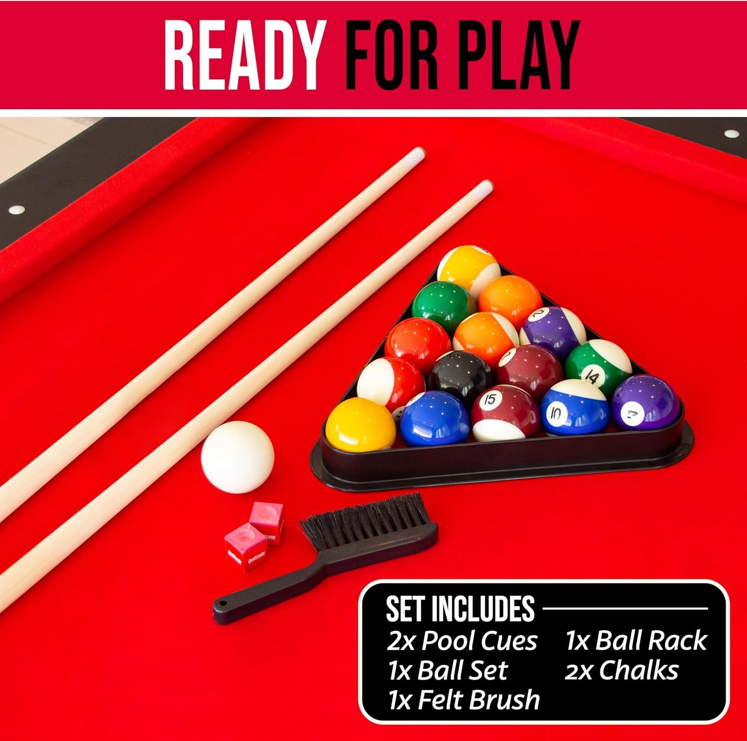 Close-up of accessories on red felt showing two cues, racked balls, cue ball, chalk cubes and a felt brush
