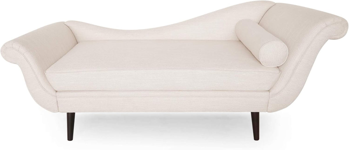Light brown upholstered chaise with scrolled arms, bolster pillow and dark tapered wooden legs on white background