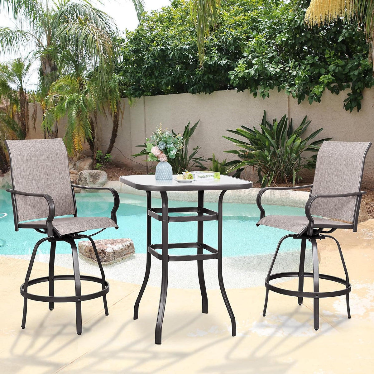 Two swivel bar chairs and square-top table at poolside with a small vase and book on the tabletop